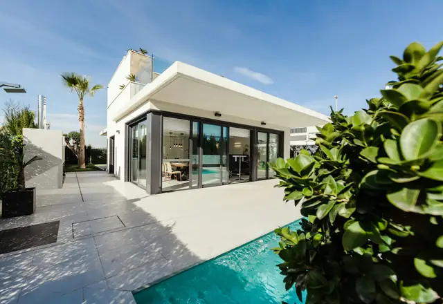 White modern home with a pool and garden
