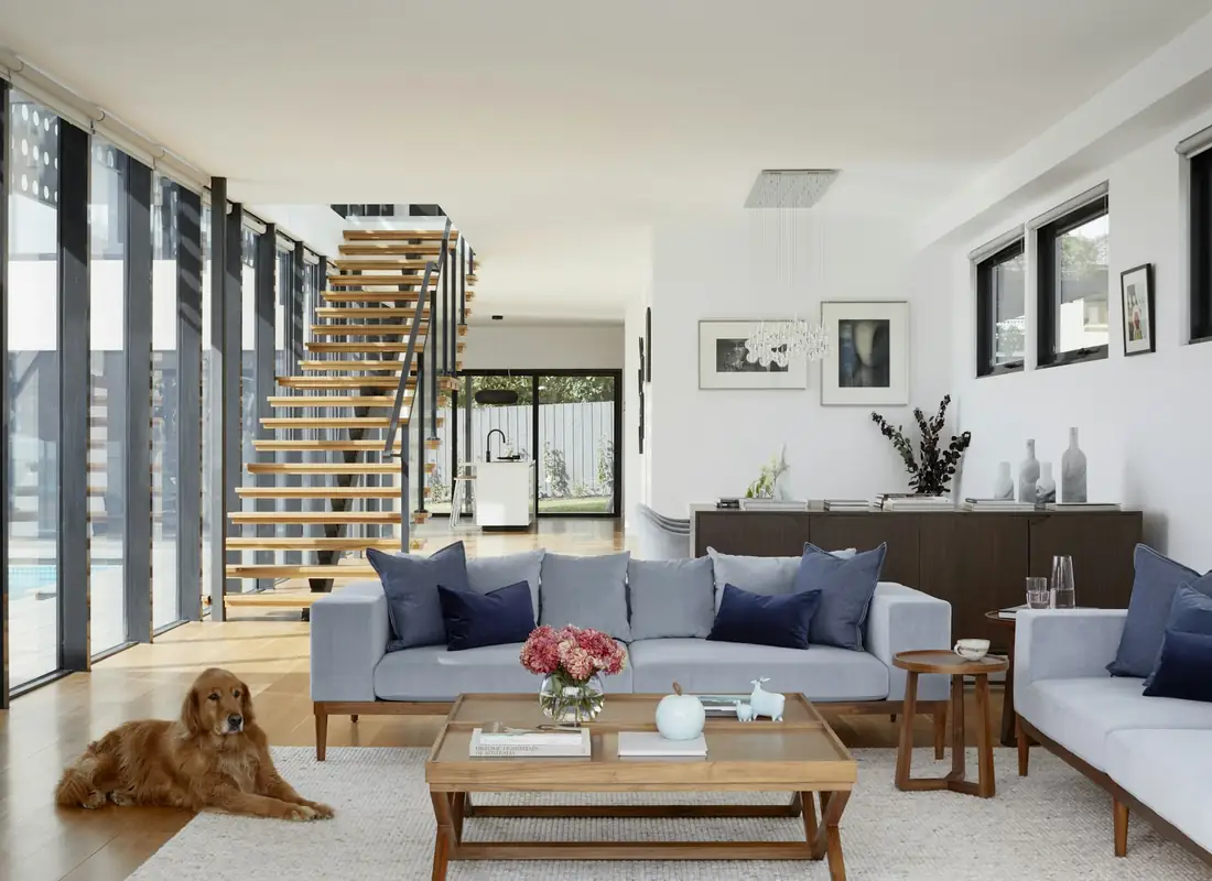 Great room with a floating staircase and kitchen beyond